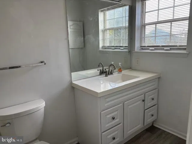 a bathroom with a sink toilet and window