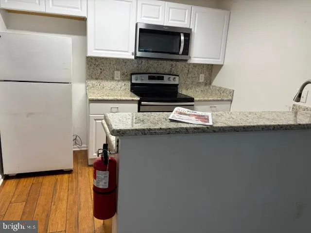 a kitchen with granite countertop a sink and a stove top oven