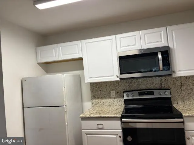 a white stove top oven sitting inside of a kitchen