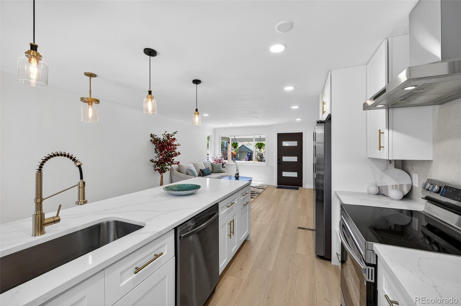 a kitchen with kitchen island granite countertop a sink stainless steel appliances and cabinets
