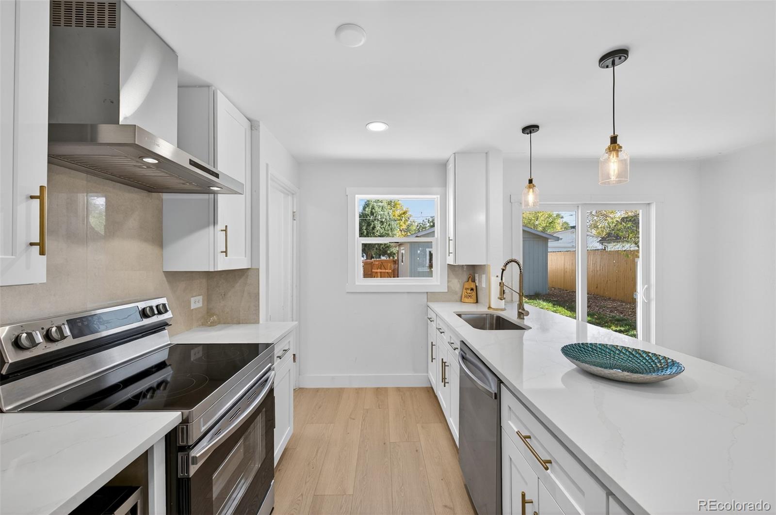 1856 South Steele Street Denver, CO 80210 - Photo 14 of 34 a kitchen that has a sink a stove and chairs