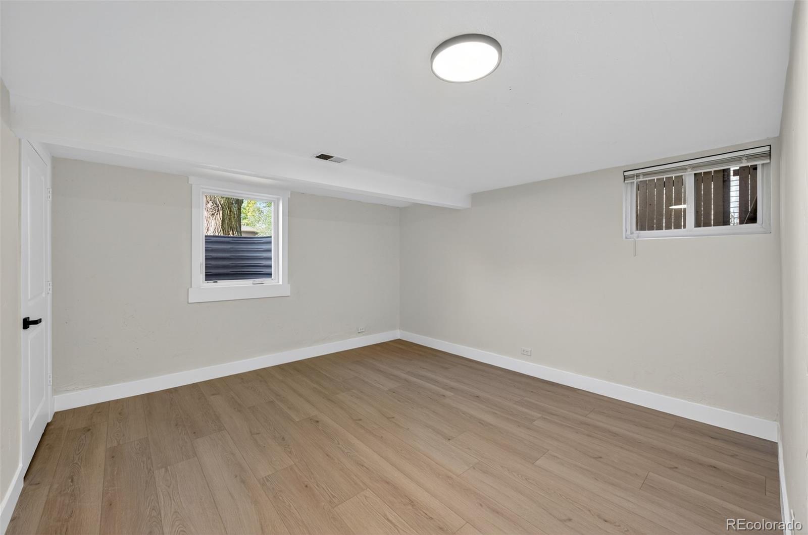 1856 South Steele Street Denver, CO 80210 - Photo 26 of 34 a view of an empty room with wooden floor and a window