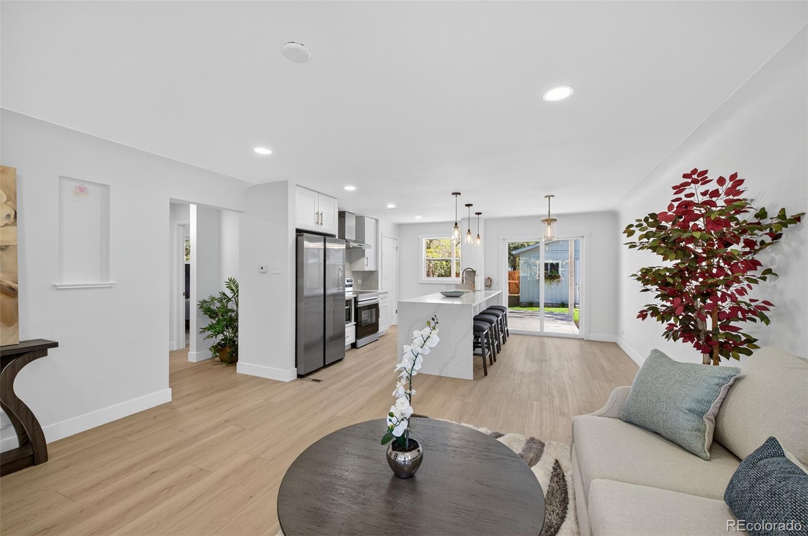1856 South Steele Street Denver, CO 80210 - Photo 9 of 34 a living room with furniture potted plant and kitchen view