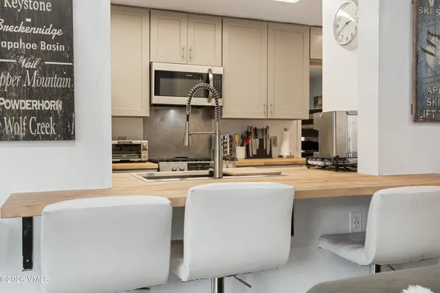 a kitchen with stainless steel appliances a sink a stove a microwave a sink and cabinets