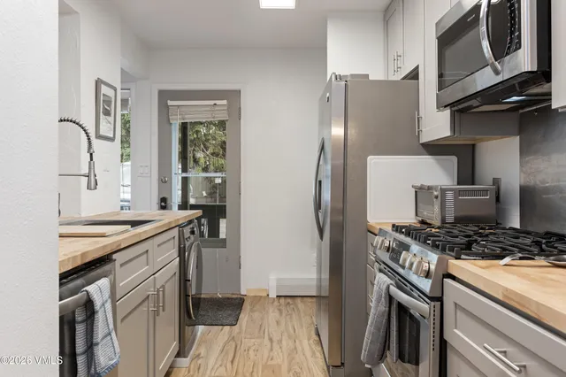 a kitchen with stainless steel appliances granite countertop a stove a refrigerator and a microwave