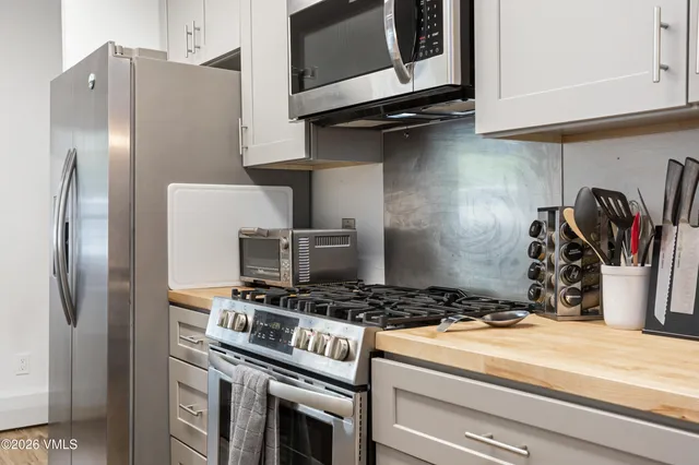 a kitchen with stainless steel appliances granite countertop a refrigerator and a stove