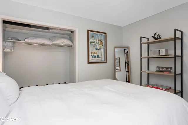 a bedroom with a bed and a painting on the wall