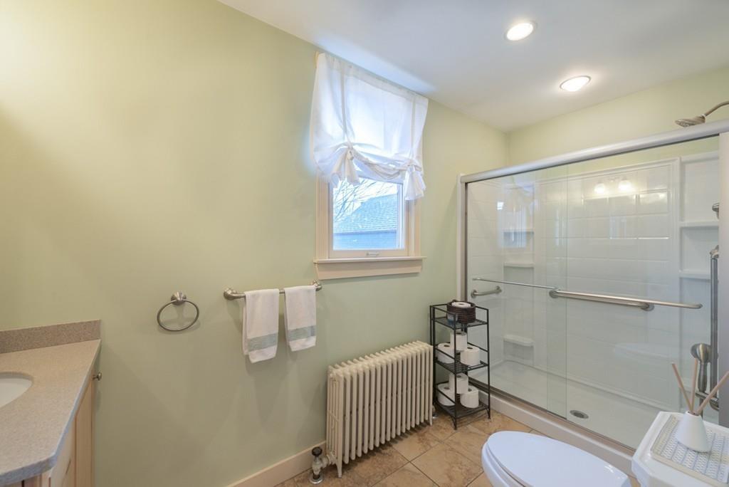 187 Pleasant Street Framingham, MA 01701 - Photo 12 of 39 a bathroom with a granite countertop bathtub shower sink mirror and toilet