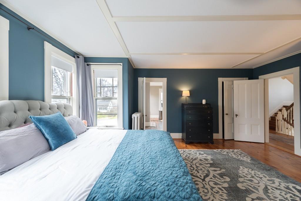 187 Pleasant Street Framingham, MA 01701 - Photo 25 of 39 a spacious bedroom with a large bed and wooden floor