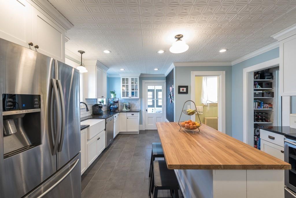 187 Pleasant Street Framingham, MA 01701 - Photo 9 of 39 a large kitchen with kitchen island a refrigerator a stove a sink a dining table and chairs