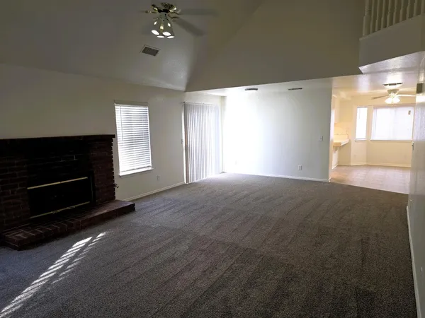 a view of an empty room with a fireplace and a window