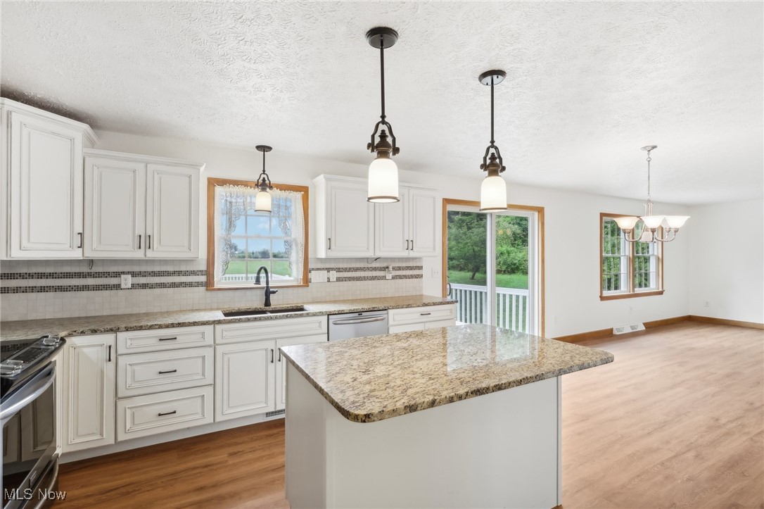 476 Garrison Road Ashtabula, OH 44004 - Photo 33 of 50 Kitchen featuring tasteful backsplash, pendant lighting, sink, appliances with stainless steel finishes, and light hardwood / wood-style flooring