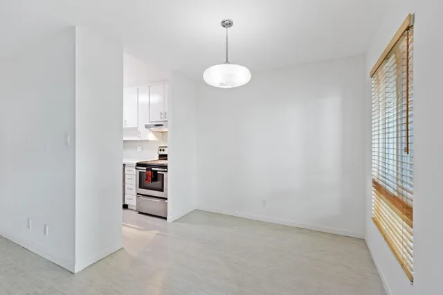an empty room with a windows and ceiling fan