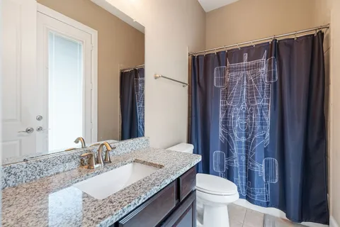 a bathroom with a granite countertop sink toilet and shower