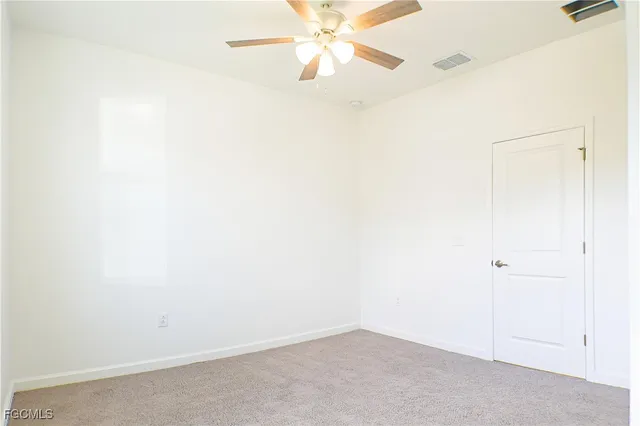 an empty room with a ceiling fan and a window