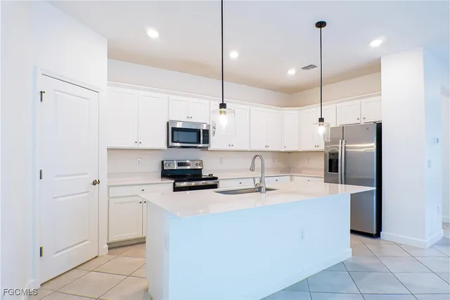 a kitchen with stainless steel appliances a refrigerator sink and microwave