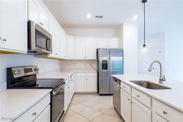 a kitchen with stainless steel appliances granite countertop a sink a stove a refrigerator and cabinets