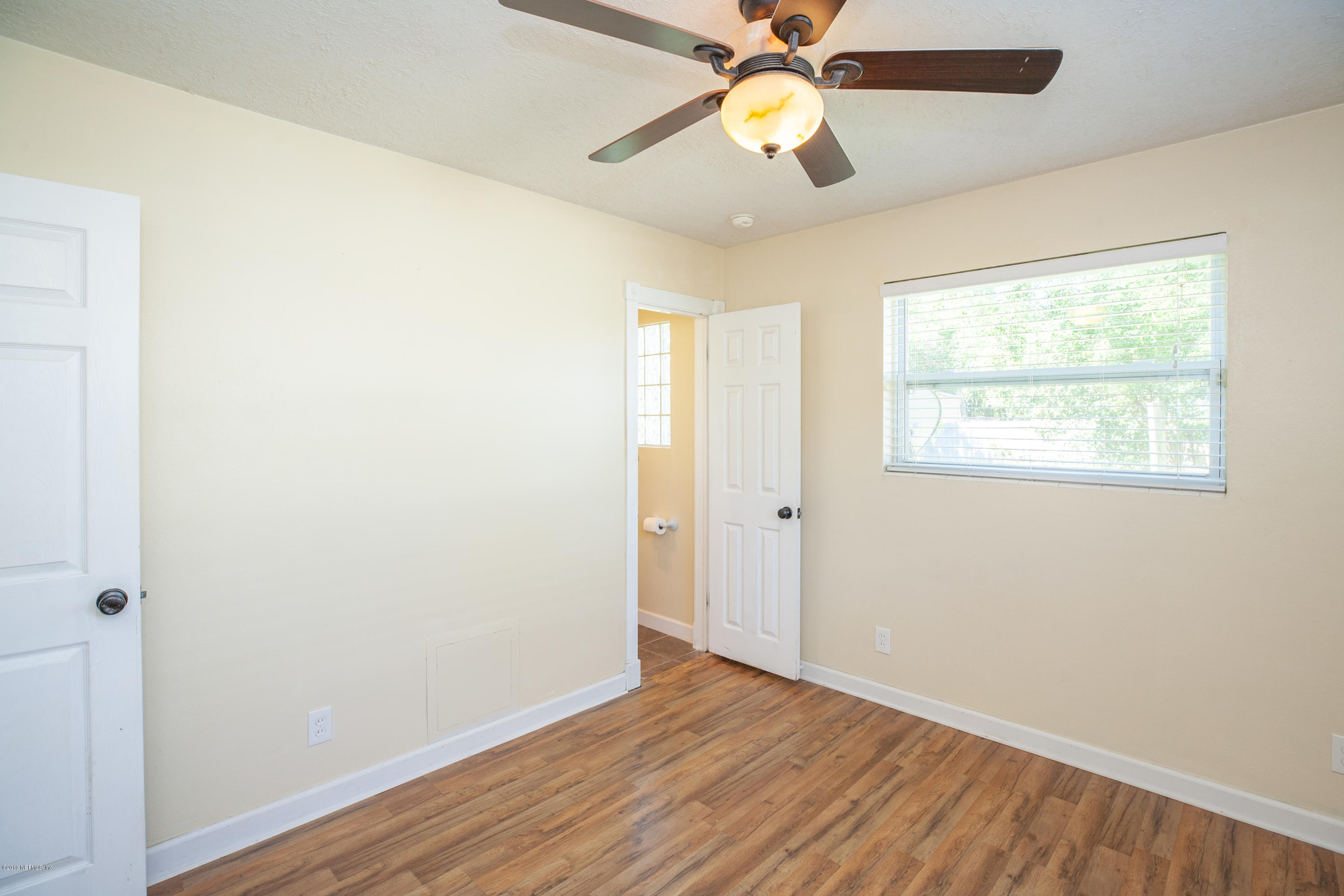 3770 Rogero Road Jacksonville, FL 32277 - Photo 19 of 27 a view of an empty room with wooden floor and a window