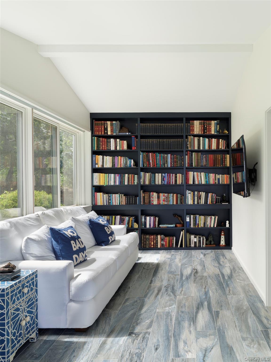 2 Sun Court Hampton Bays, NY 11946 - Photo 11 of 35 a living room with furniture and a book shelf