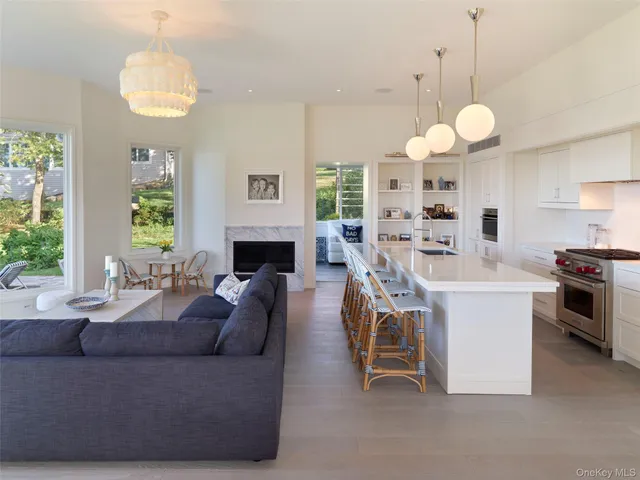 a living room with furniture a fireplace and a chandelier
