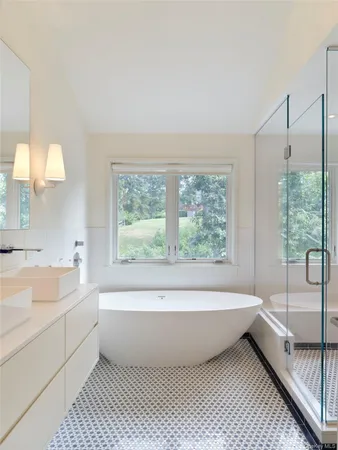 a bathroom with a large tub a vanity and a large window