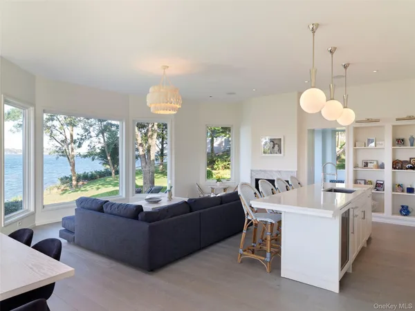 a living room with furniture a chandelier and a large window