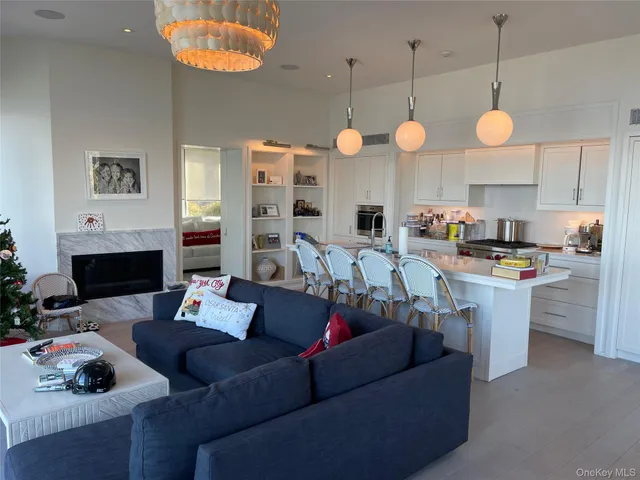 a living room with furniture kitchen view and a chandelier