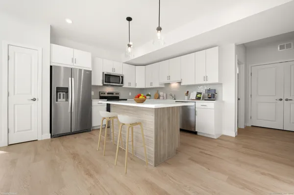 a kitchen with stainless steel appliances a refrigerator sink and cabinets