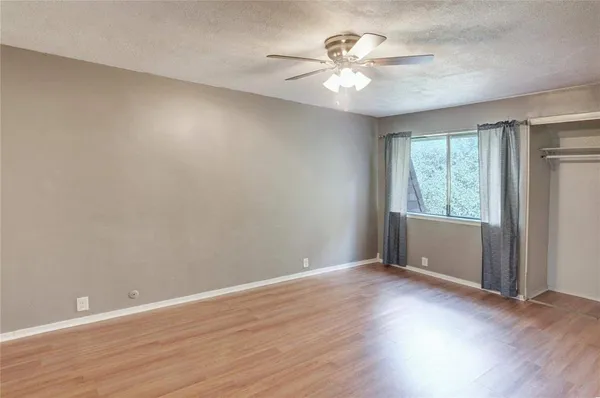 a view of an empty room with wooden floor