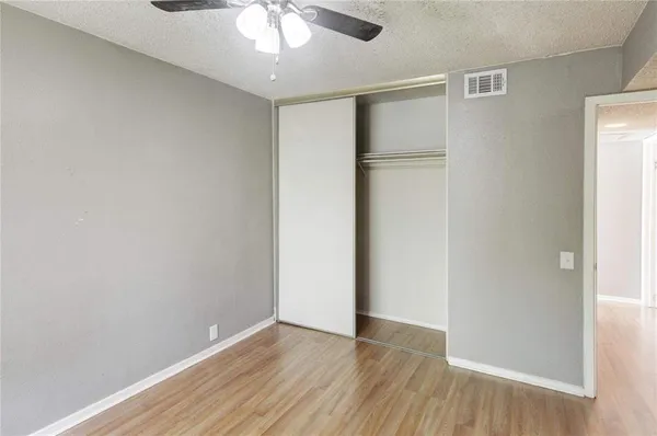 an empty room with closet and chandelier fan