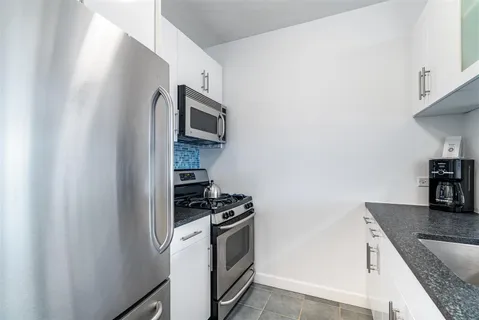 a kitchen with stainless steel appliances granite countertop a stove a microwave and a sink