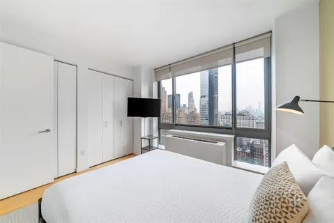 a bedroom with a large bed and a large window