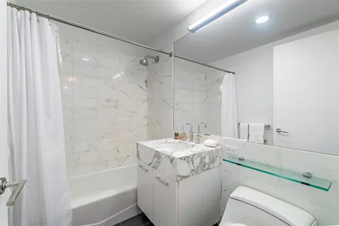 a bathroom with a sink toilet tub and shower