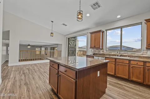 a kitchen with stainless steel appliances granite countertop hardwood floor sink stove and wooden cabinets