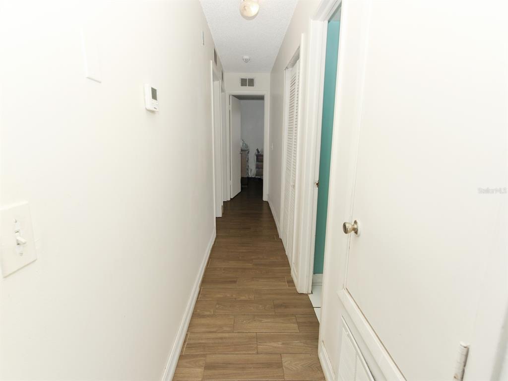 4173 Signal Hill Road Orlando, FL 32808 - Photo 4 of 22 a view of a hallway with wooden floor and a bathroom