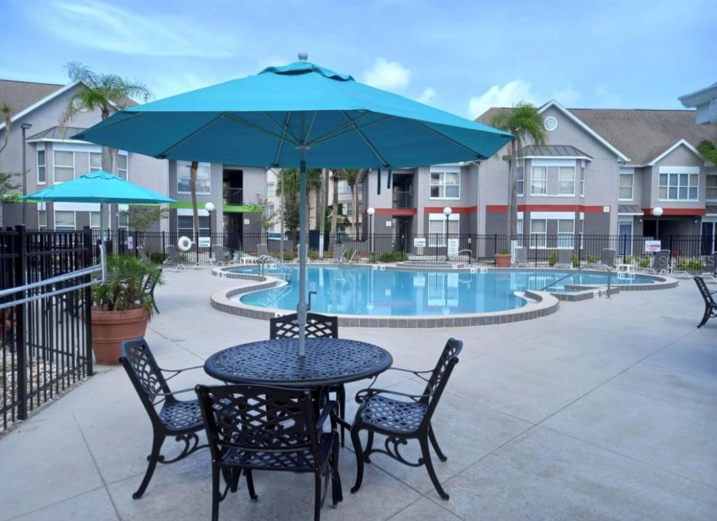 3100 Parkway Boulevard, Unit 511 Kissimmee, FL 34747 - Photo 28 of 40 a patio with a table and chairs under an umbrella