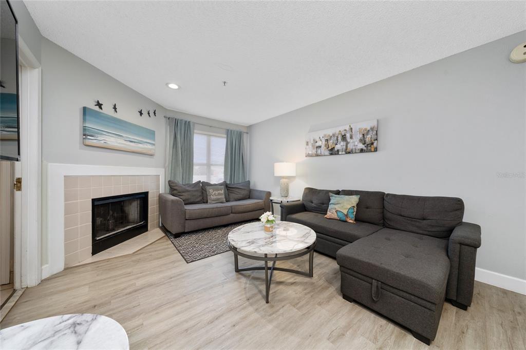 3100 Parkway Boulevard, Unit 511 Kissimmee, FL 34747 - Photo 5 of 40 a living room with furniture a fireplace and a table