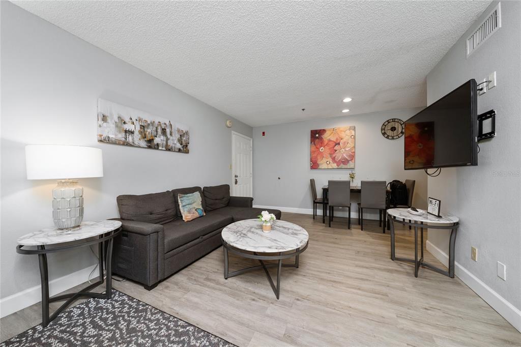 3100 Parkway Boulevard, Unit 511 Kissimmee, FL 34747 - Photo 8 of 40 a living room with furniture a flat screen tv and a table