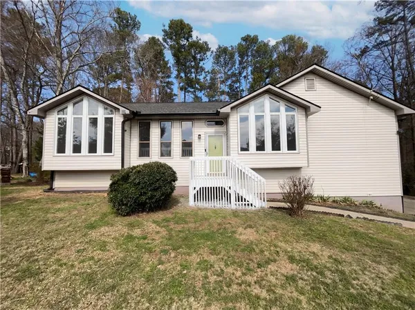 a front view of a house with a garden