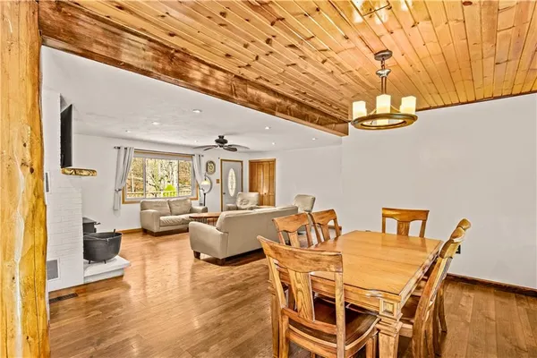 a dining room with furniture a chandelier and wooden floor