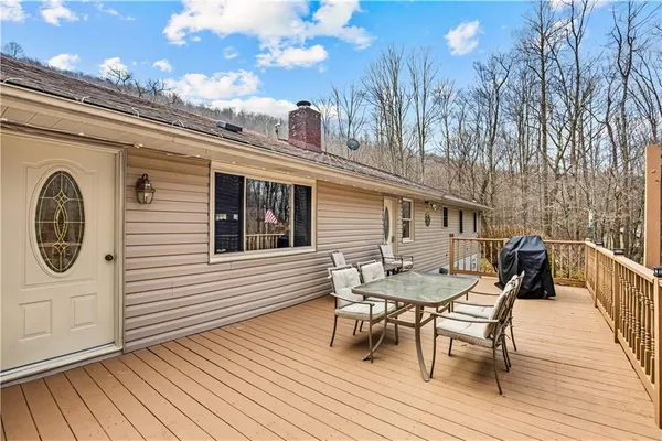 a view of a roof deck with table and chairs and wooden floor