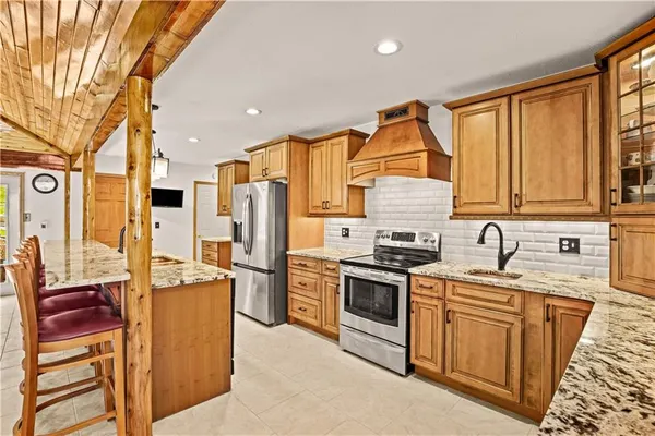 a kitchen with stainless steel appliances granite countertop a stove refrigerator sink and cabinets