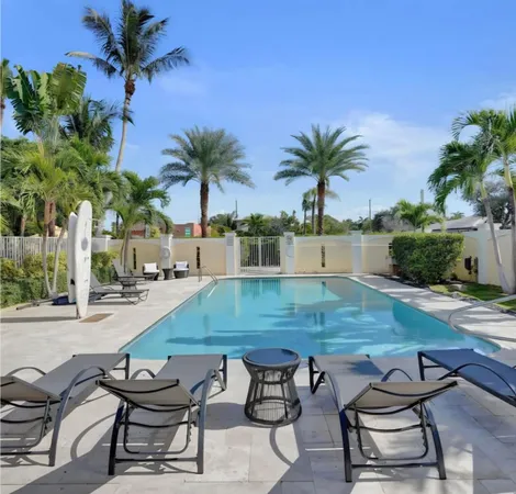 a view of a backyard with swimming pool and sitting area