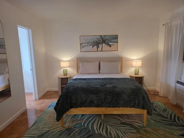 a bedroom with a large bed and a rug