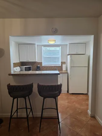 a kitchen with a table chairs refrigerator and microwave