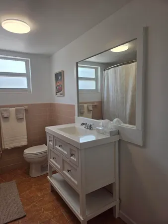 a bathroom with a sink toilet and mirror