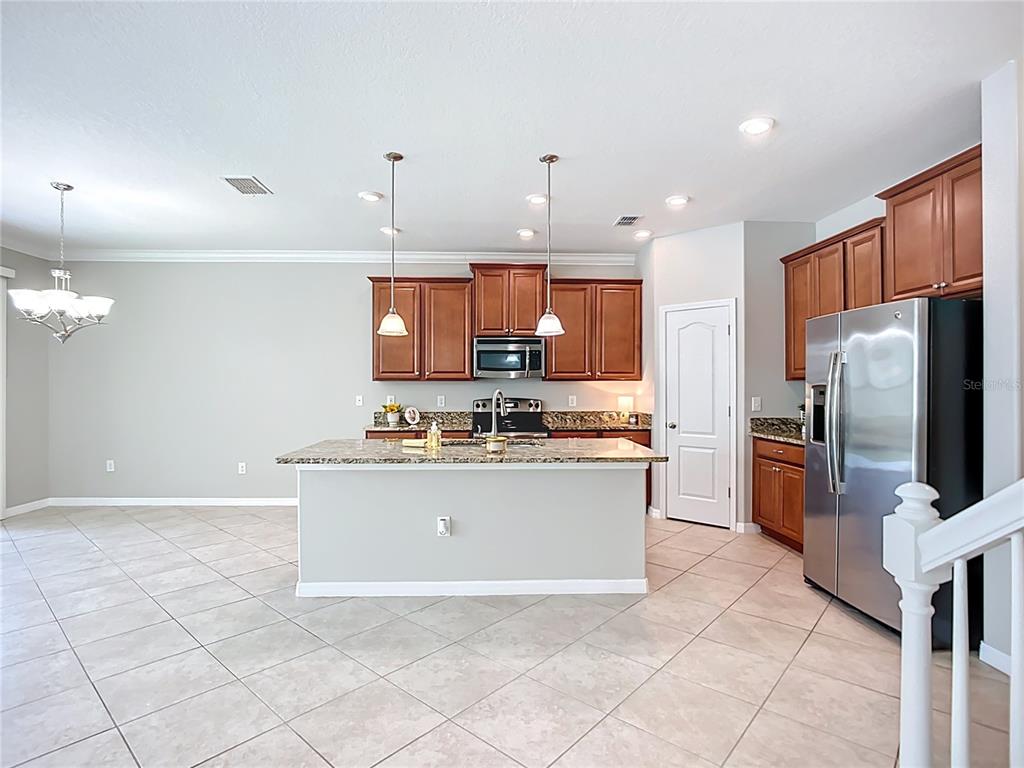 14240 Blue Dasher Drive Riverview, FL 33569 - Photo 20 of 66 a kitchen with stainless steel appliances granite countertop a refrigerator a stove a sink and a microwave