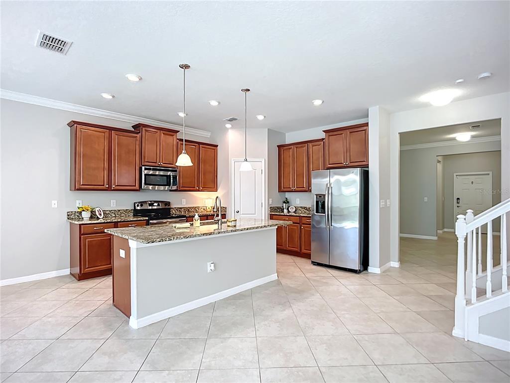 14240 Blue Dasher Drive Riverview, FL 33569 - Photo 21 of 66 a kitchen with stainless steel appliances granite countertop a stove top oven a sink and a refrigerator