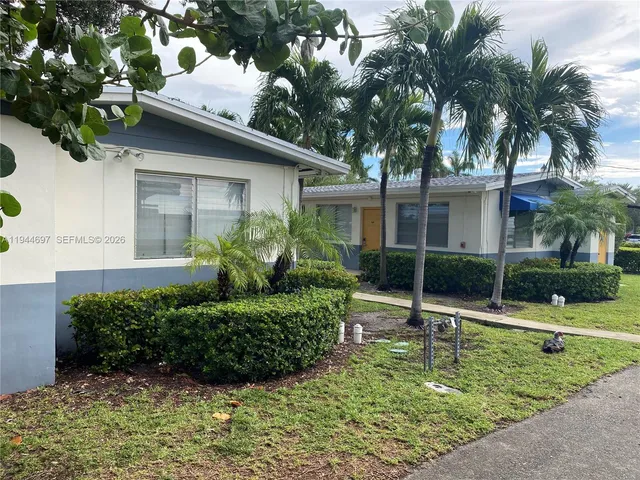 a view of a house with a yard and potted plants