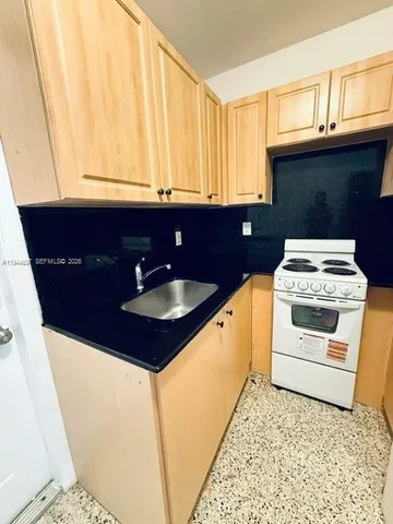 a kitchen with a sink a stove and cabinets